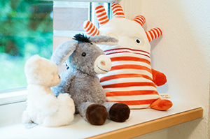 Drei Kuscheltiere auf einer Fensterbank